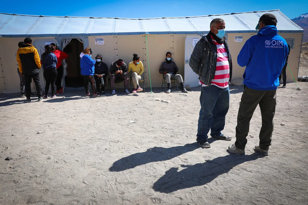 Personal de la OIM hablando con migrantes recién llegados.