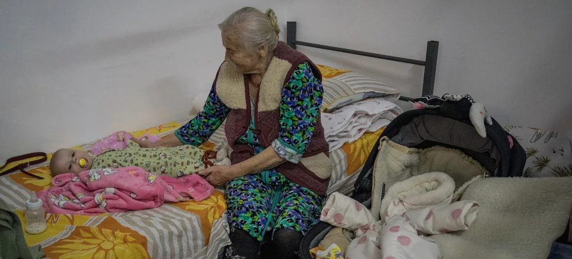 Una mujer ucraniana atiende a su bisnieto en un refugio temporal en Rumanía.