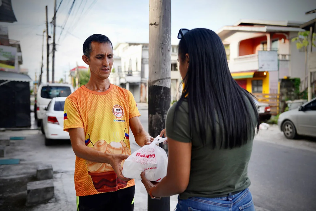 Alis, de Sr. Tequeños, entrega comida a un cliente.