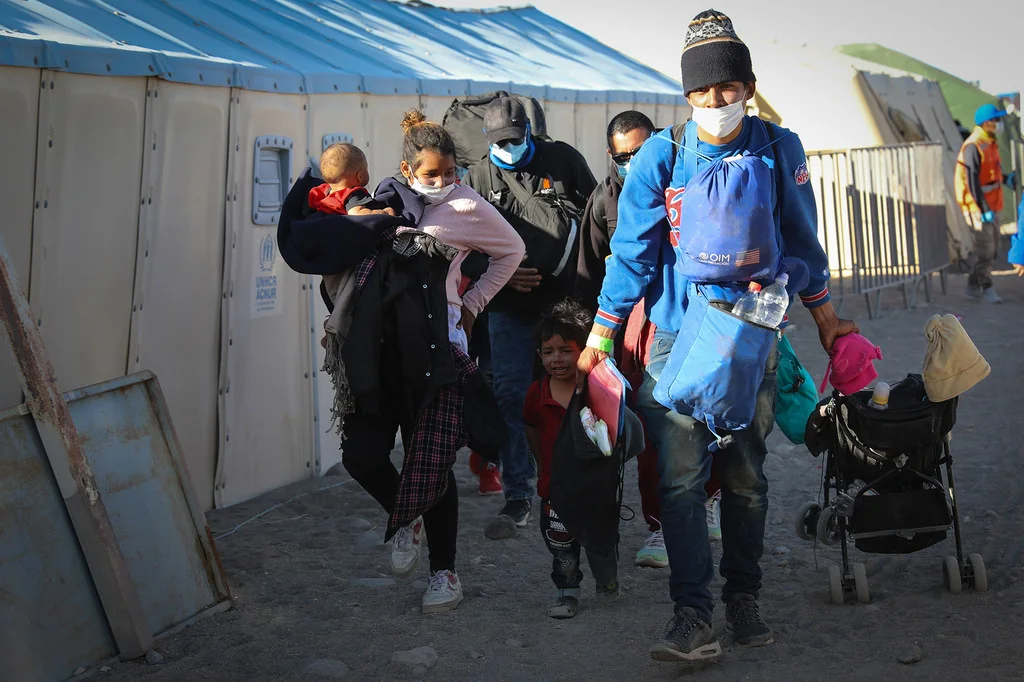 Jhonny, de 26 años, Cribsel, de 19, y sus dos niños llegan a un centro de refugiados migrantes en Colchane.